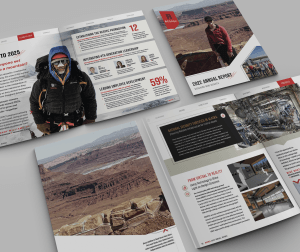 A set of open brochures displayed on a grey surface, featuring images of mountain climbers, desert landscapes, and industrial facilities, with text and charts about a companys annual report and achievements.