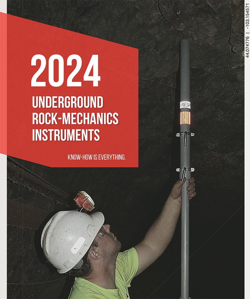 A person in a white hard hat installs a rock-mechanics instrument on the ceiling of an underground tunnel. Red text box reads “2024 Underground Rock-Mechanics Instruments. Know-how is everything.”.