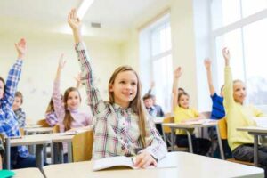 A girl raising her hand in a classroom or educational setting